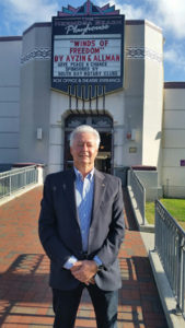 Photo of Alex Ayzin standing in front of Peace Day LA marquee at Hermosa Beach Theater. 